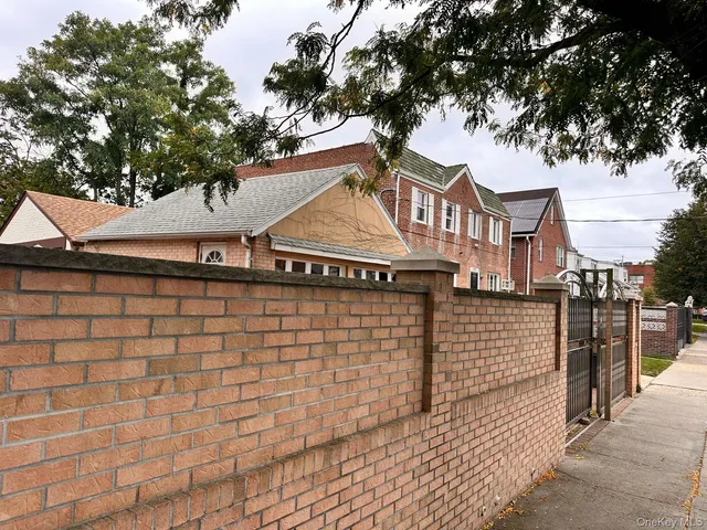 a front view of a house with a tree