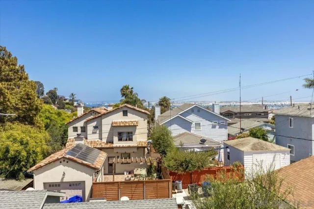 a view of a house with a clock tower in middle of a yard