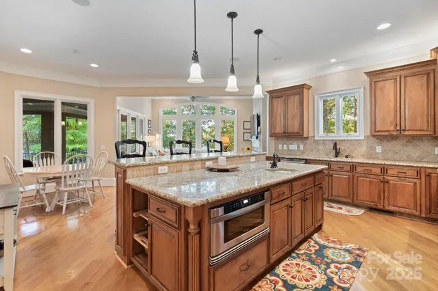 a kitchen with stainless steel appliances granite countertop a stove and a wooden floors