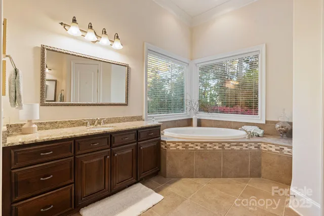 a bathroom with a tub sink and mirror