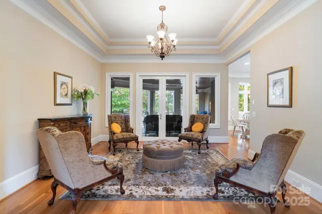 a living room with furniture chandelier and a table