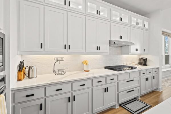 1825 Rough Rdg Trail Midlothian, TX 76065 - Photo 12 of 37 Contemporary kitchen featuring two-tone cabinetry with matte black hardware, white countertops, and a white textured backsplash