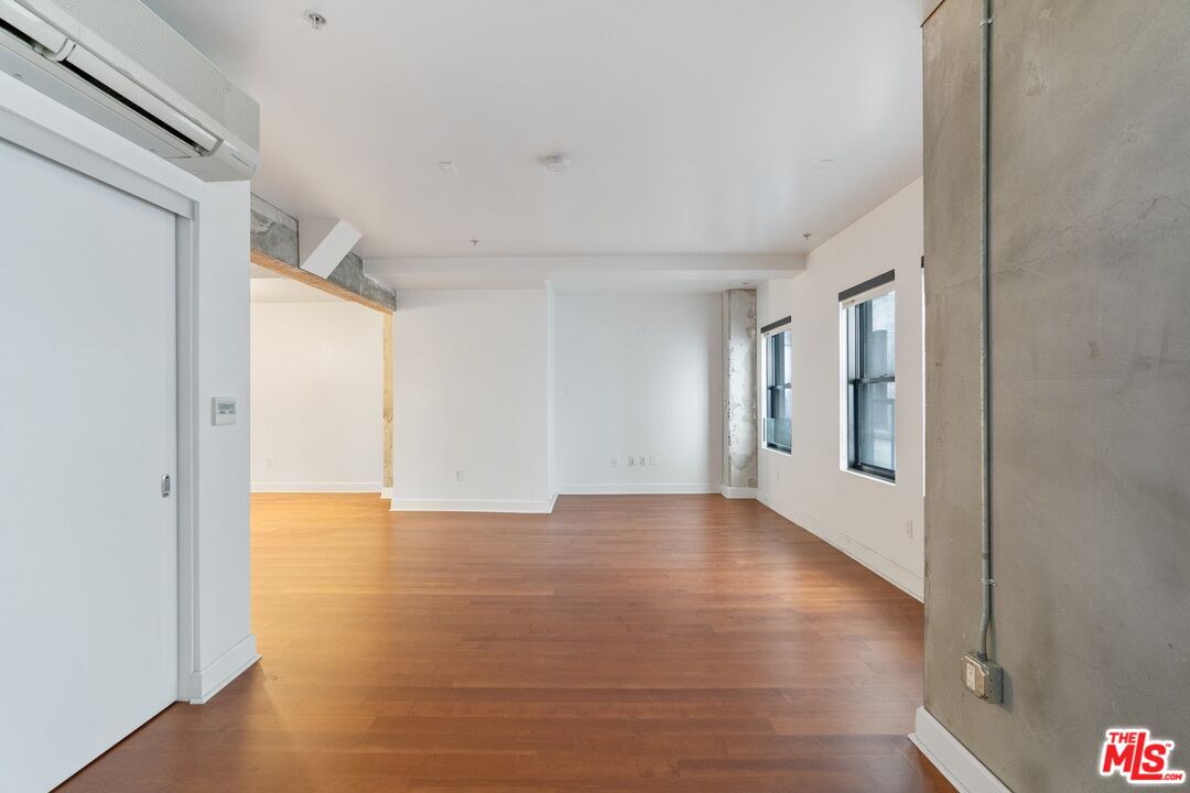 416 South Spring Street, Unit 210 Los Angeles, CA 90013 - Photo 4 of 18 a view of an empty room with wooden floor and a window