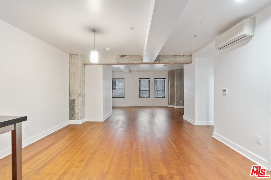 416 South Spring Street, Unit 210 Los Angeles, CA 90013 - Photo 6 of 18 wooden floor in an empty room with a window