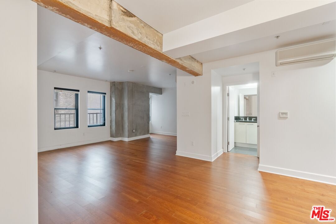 416 South Spring Street, Unit 210 Los Angeles, CA 90013 - Photo 10 of 18 a view of an empty room with wooden floor and a window