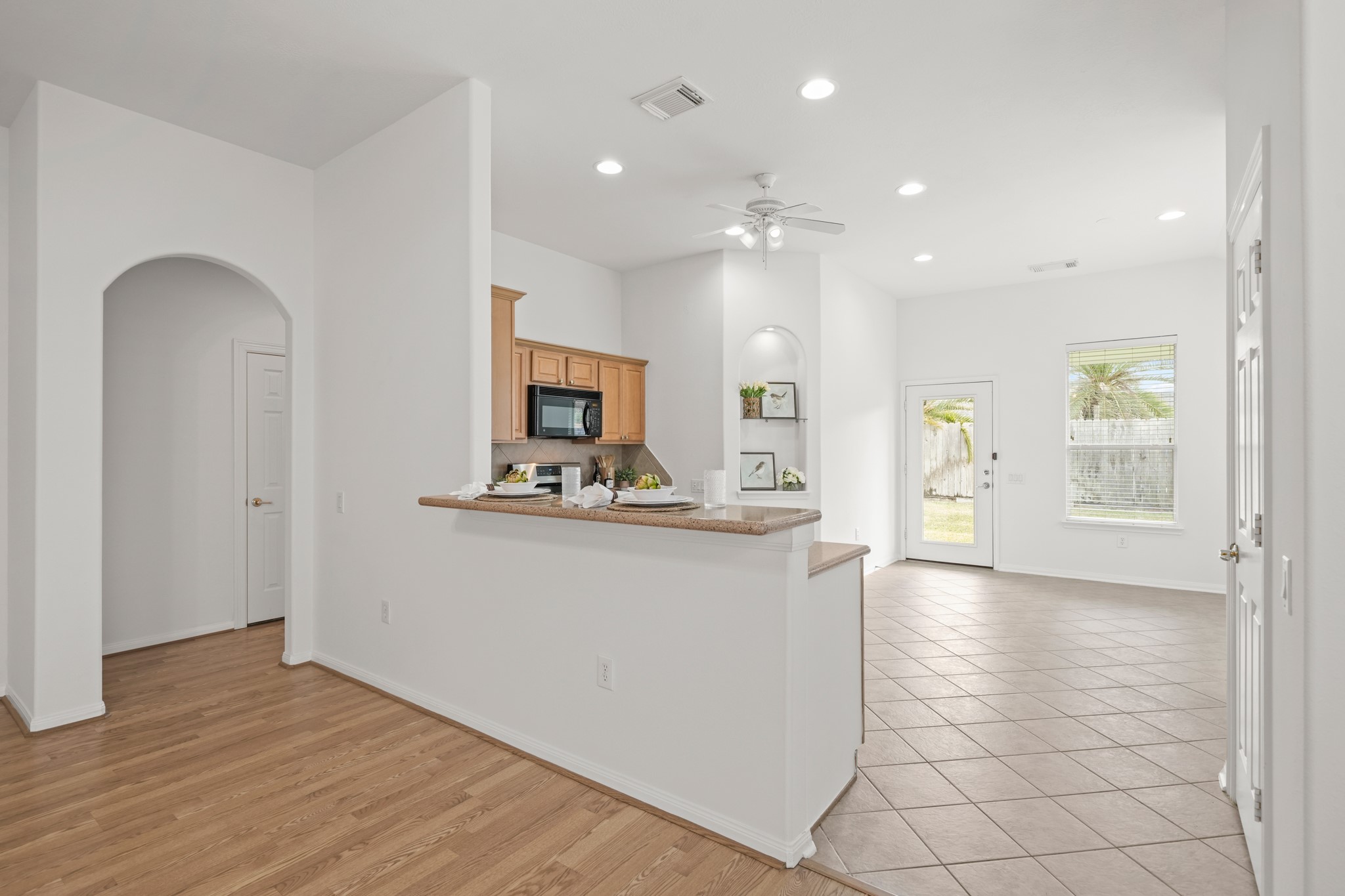 25003 Spring Ash Lane Katy, TX 77494 - Photo 10 of 43 The breakfast bar is a stylish and efficient hub perfect for relaxed meals and lively gatherings, seamlessly blending function and charm to the kitchen. In the background sits the entrance to the primary bedroom.