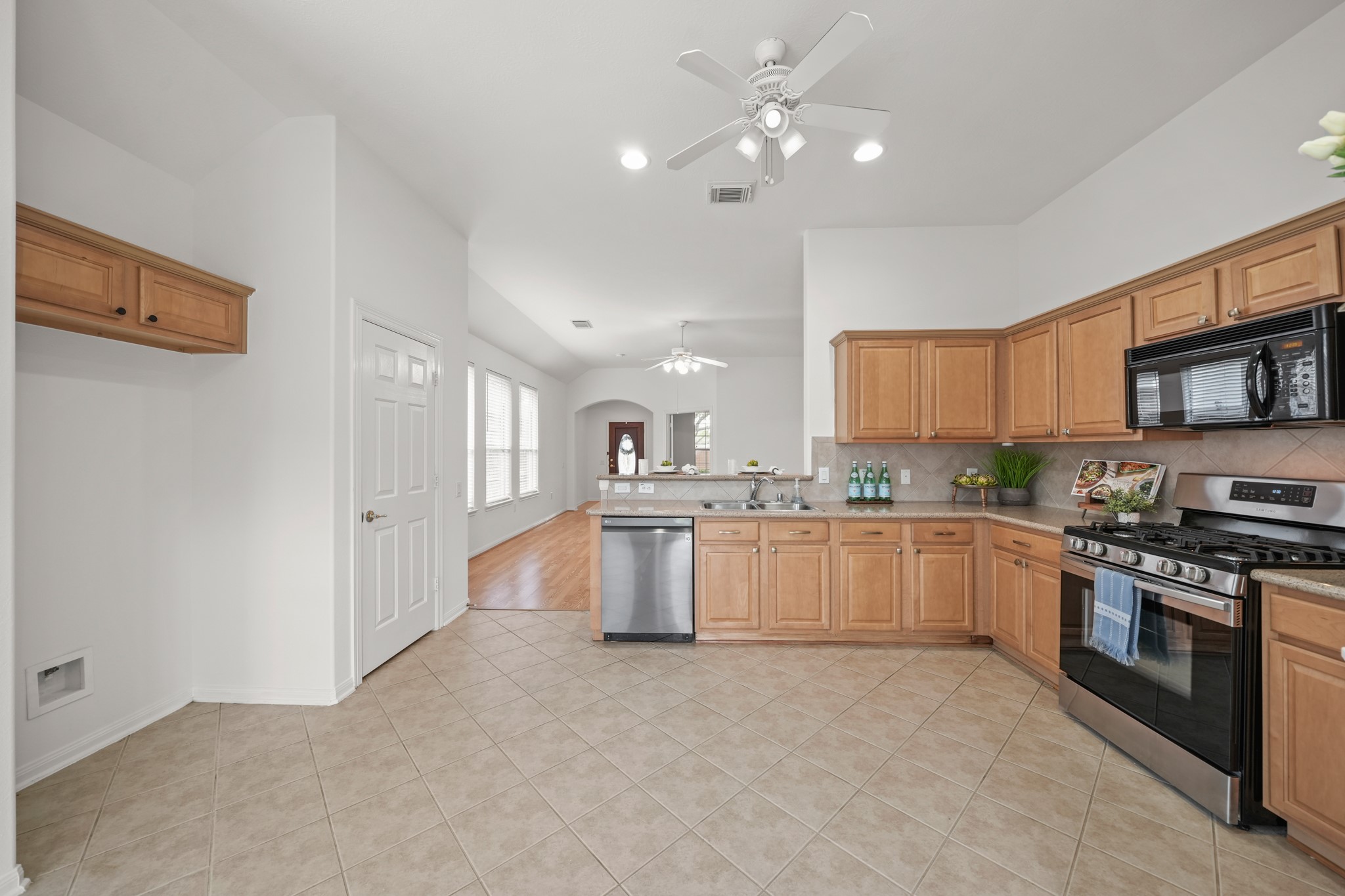 25003 Spring Ash Lane Katy, TX 77494 - Photo 15 of 43 This inviting space features a space for a refrigerator with cabinets above and a roomy pantry on the left, blending the open kitchen-to-living area, perfect for casual dining and lively conversation.
