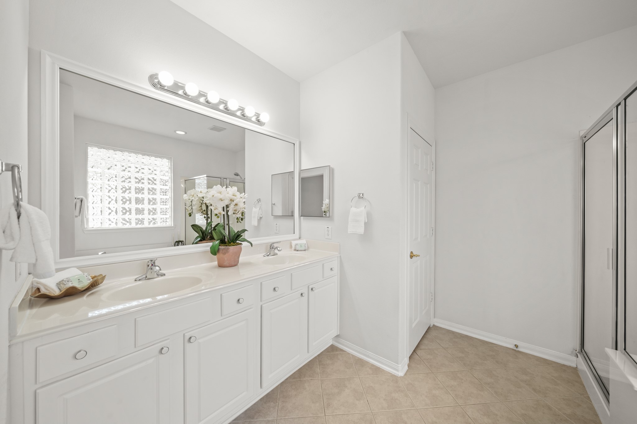 25003 Spring Ash Lane Katy, TX 77494 - Photo 23 of 43 Discover functionality in this primary bath, featuring dual sinks, a sleek cultured marble countertop and a framed mirror with decorative lighting above and a medcine cabinet to the right. A private water closet sits through the door on the left.