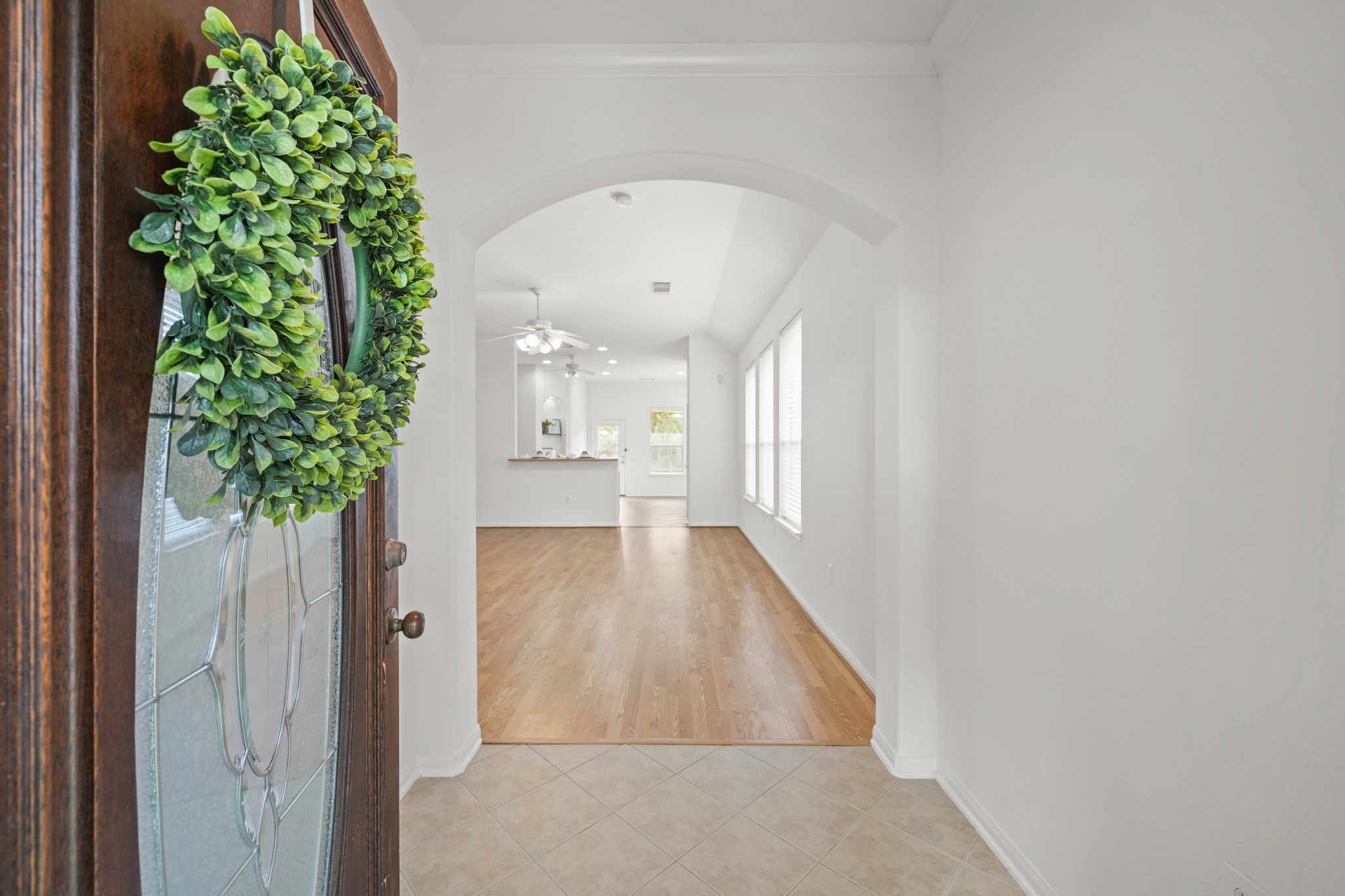 25003 Spring Ash Lane Katy, TX 77494 - Photo 2 of 43 Step through the elegant glass door into a bright foyer adorned with tile floors and crown moulding, where a graceful arch warmly welcomes you into the heart of the home.