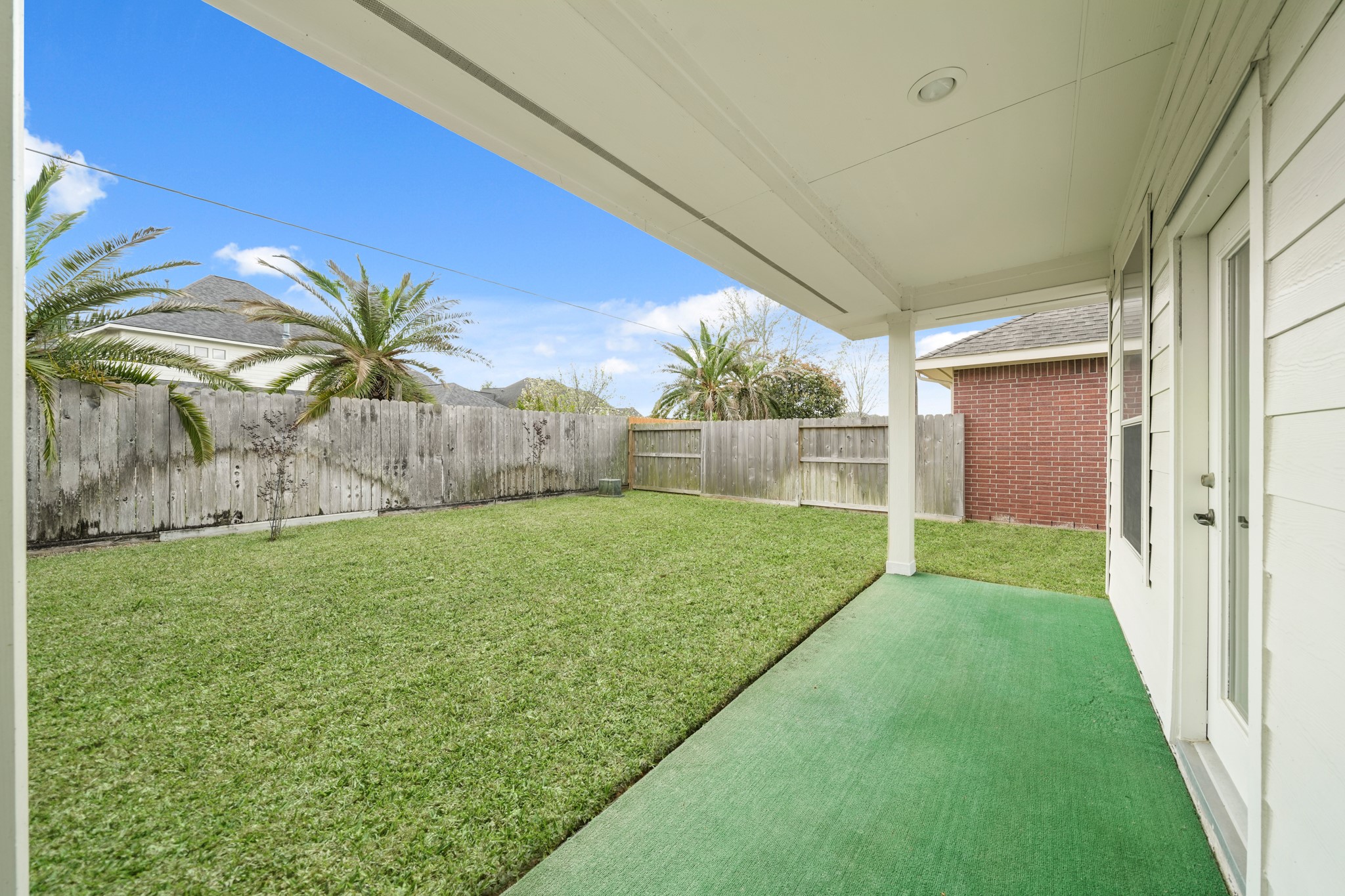 25003 Spring Ash Lane Katy, TX 77494 - Photo 39 of 43 The back patio, with its covered design, artificial turfed flooring and kitchen access, offers a relaxed extension of your home, perfect for hosting BBQs, making S’mores and creating special everyday moments.