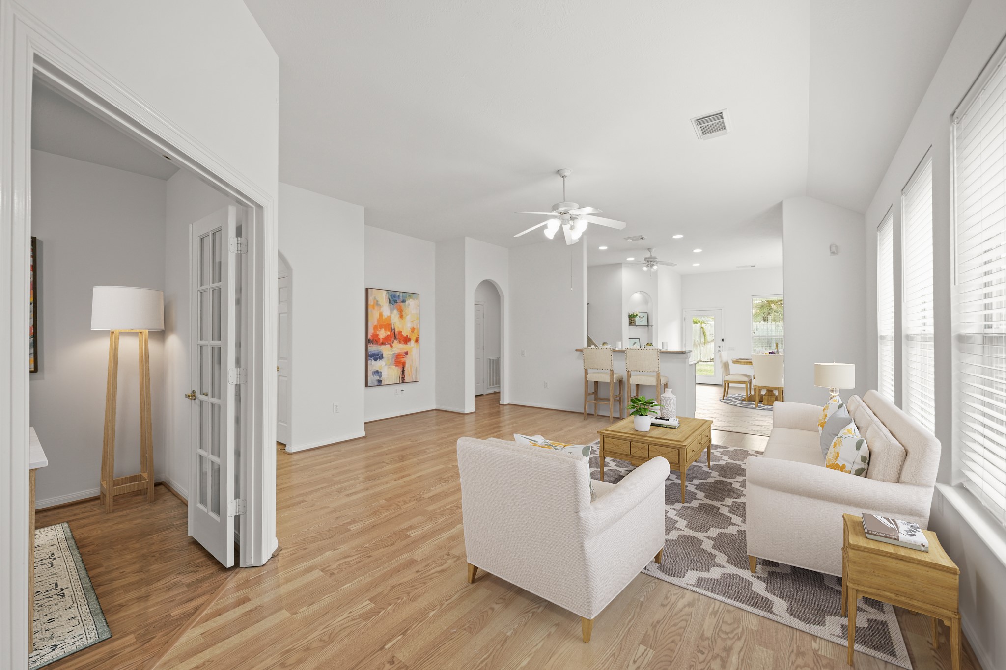 25003 Spring Ash Lane Katy, TX 77494 - Photo 6 of 43 Experience the elegance of this family room with its gleaming laminate hardwood floors, ceiling fan with integrated light, and inviting windows adorned with blinds.