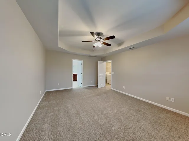 a view of an empty room with a ceiling fan