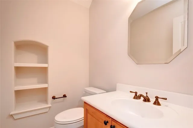 a bathroom with a sink a toilet and mirror