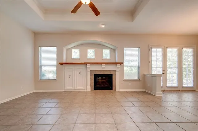 an empty room with windows and fireplace