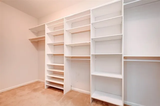 a view of walk in closet with empty racks