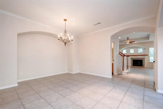 a view of a livingroom with a ceiling fan a fireplace and chandelier
