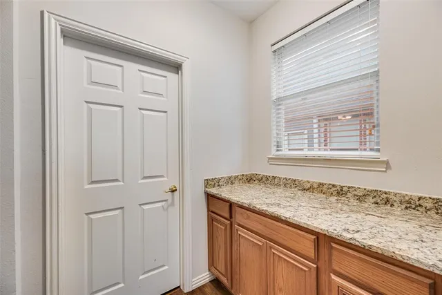 a view of kitchen with granite countertop cabinets sink and window
