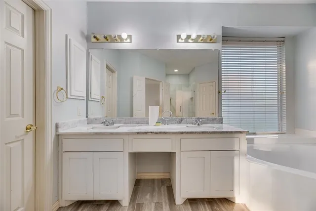 a bathroom with a sink and a wooden floor
