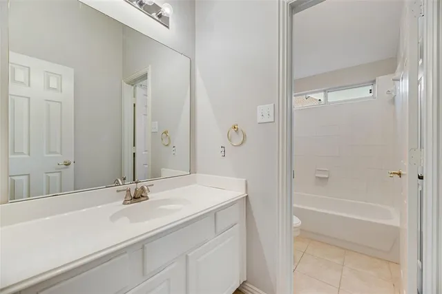 a bathroom with a sink tub vanity and a mirror