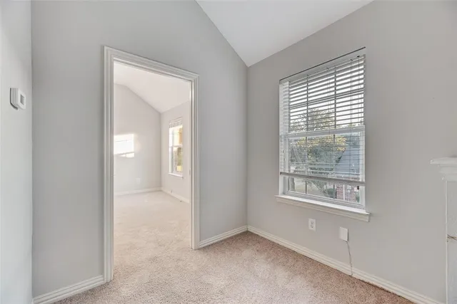a view of an empty room with window and closet area