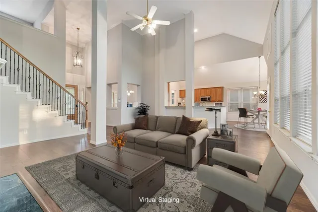 a living room with furniture kitchen view and a chandelier