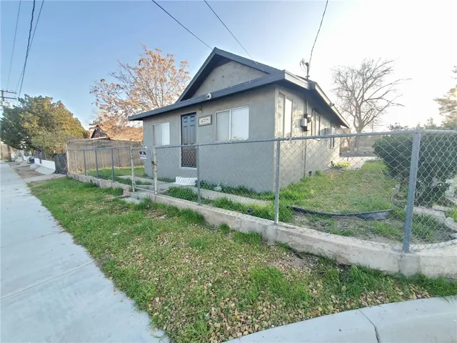 a white house that has tree in front of it