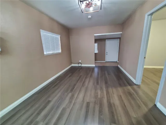 a view of a room with wooden floor and a window