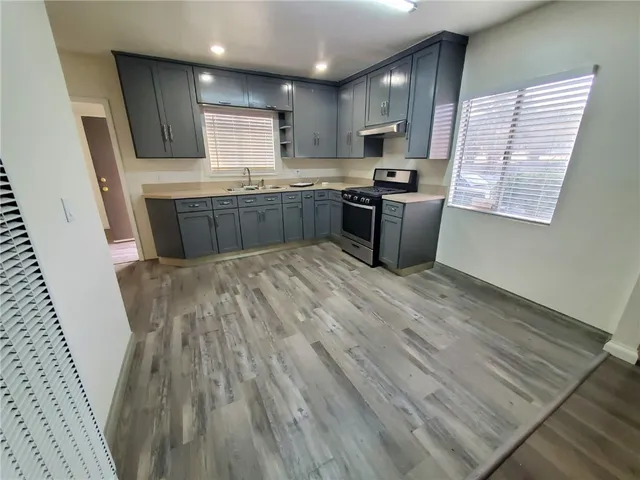 a kitchen with stainless steel appliances granite countertop a stove a sink and a microwave
