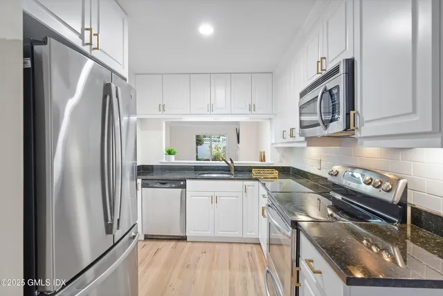 a spacious bathroom with a granite countertop sink a mirror and a shower