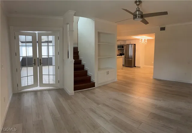 a view of a hallway with wooden floor and staircase