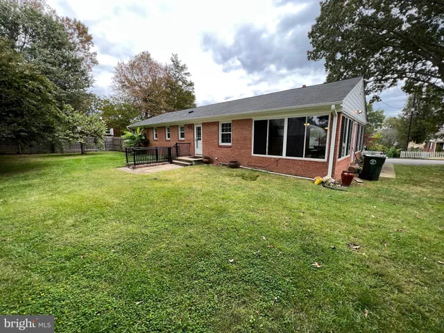 a view of a house with a big yard and large trees