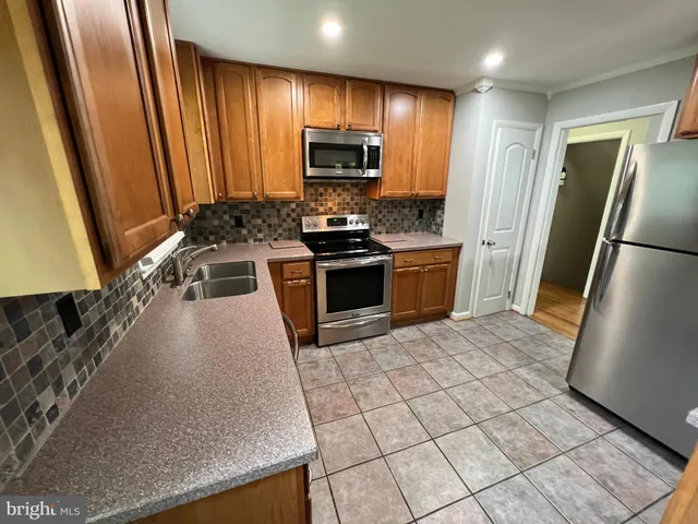 a view of a kitchen with a stove wooden floor and a window