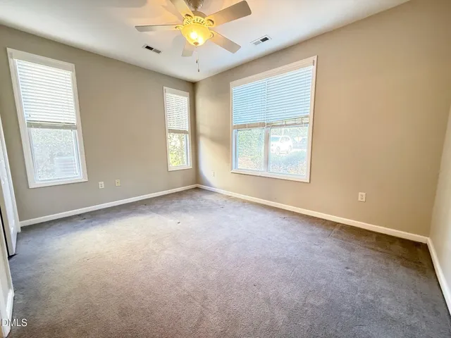 an empty room with a window and a fan