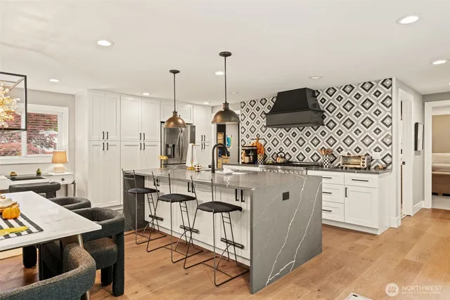 a kitchen with stainless steel appliances kitchen island granite countertop a stove a sink and a refrigerator