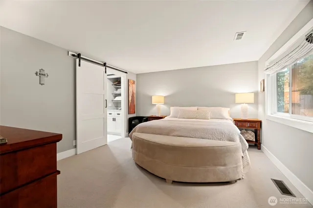 a spacious bedroom with a bed and a cabinets