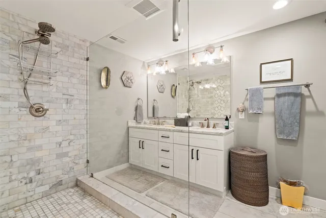 a bathroom with a double vanity sink mirror and shower