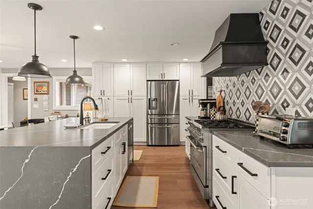 a kitchen with stainless steel appliances granite countertop a sink stove and refrigerator