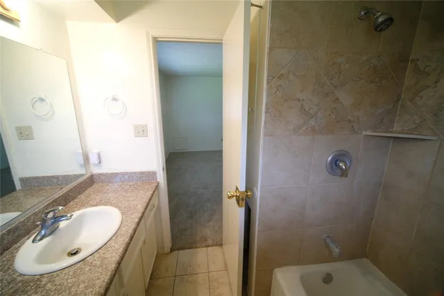 a bathroom with a granite countertop sink a mirror and shower