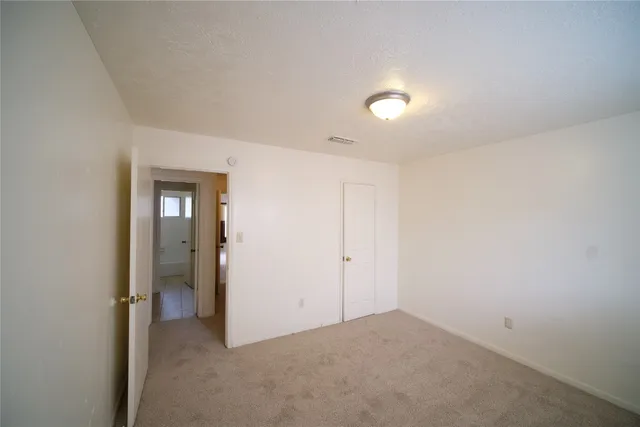 an empty room with closet and mirror