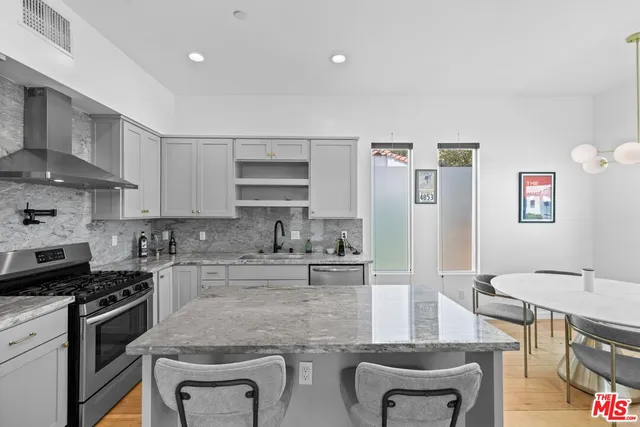a kitchen with stainless steel appliances granite countertop a sink stove and cabinets