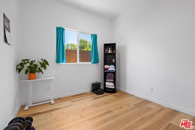 a view of a room with wooden floor and small window