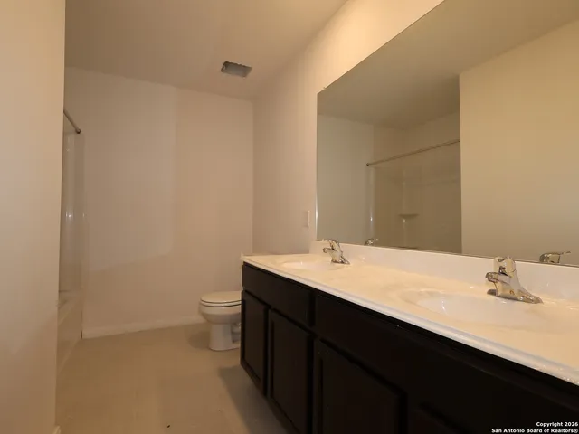 a bathroom with a sink a toilet and mirror