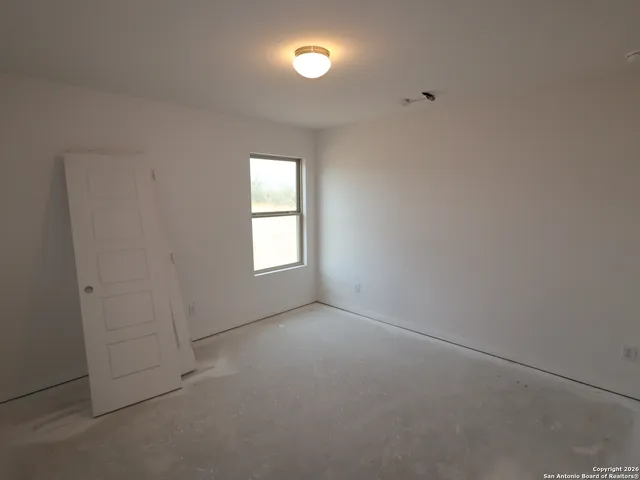 an empty room with closet and windows
