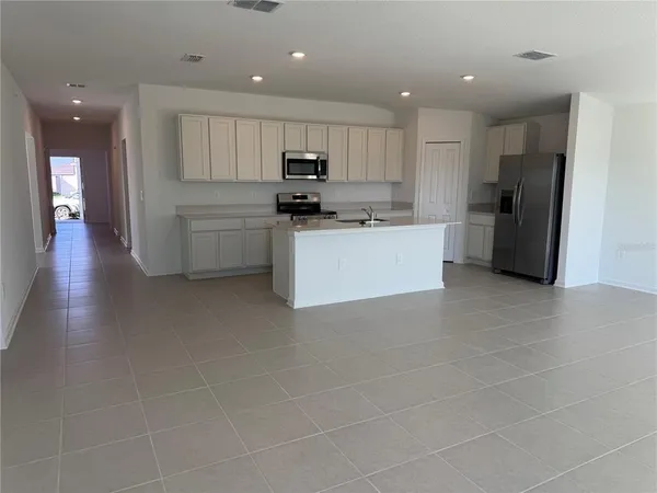 a kitchen with stainless steel appliances a refrigerator sink and cabinets