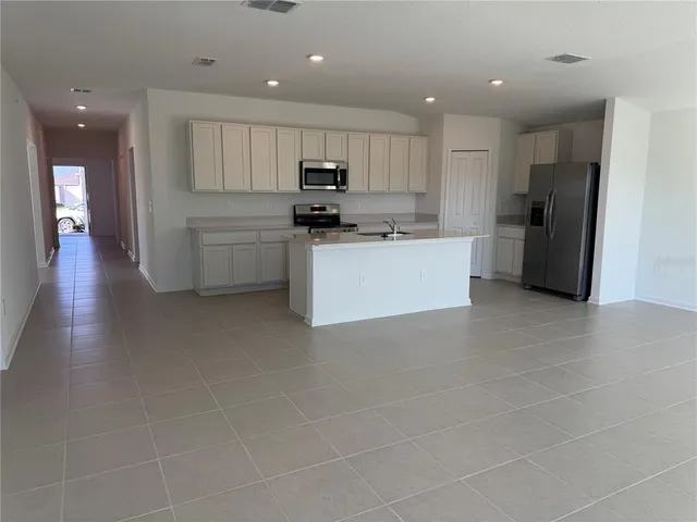 a kitchen with stainless steel appliances a refrigerator sink and cabinets