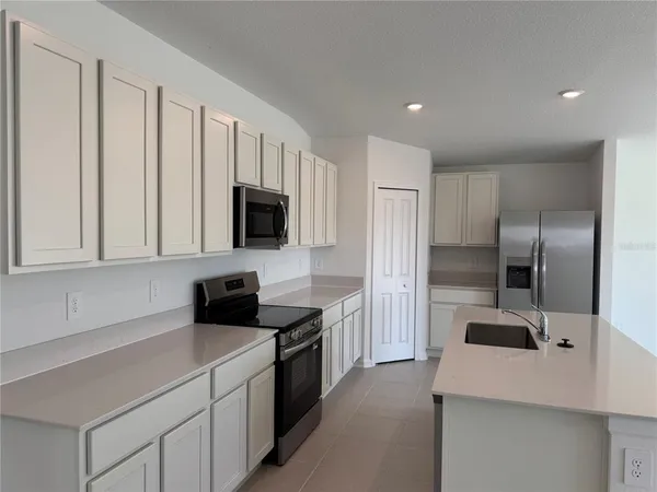 a kitchen with a refrigerator and a sink