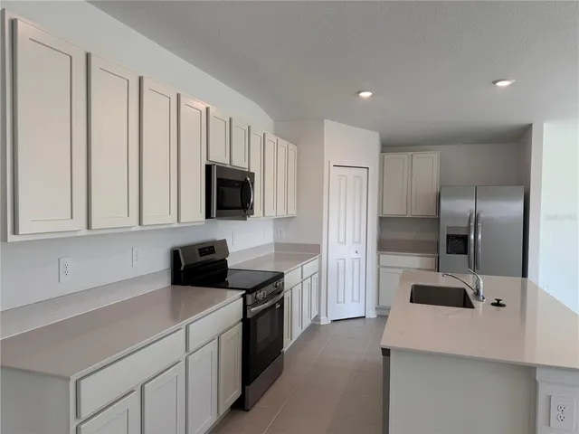 a kitchen with a refrigerator and a sink