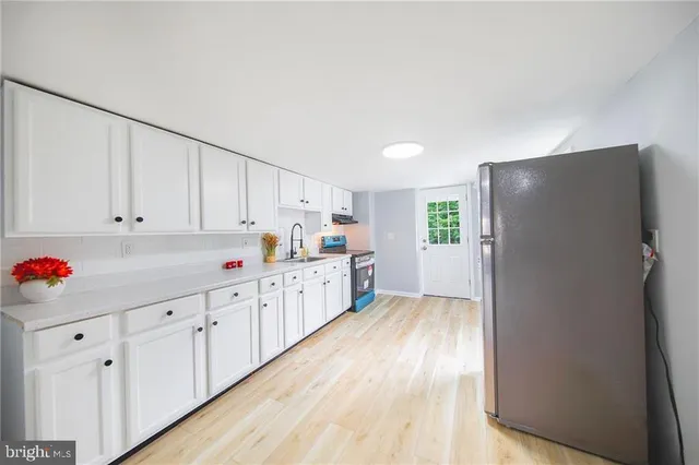 a kitchen with granite countertop white cabinets and white appliances