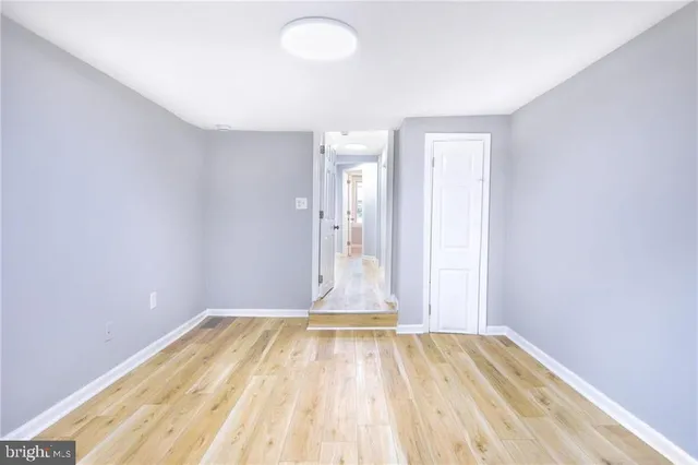 a view of a room with wooden floor and white walls