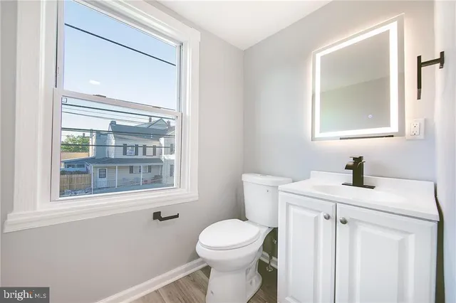 a bathroom with a toilet a sink a vanity and a mirror